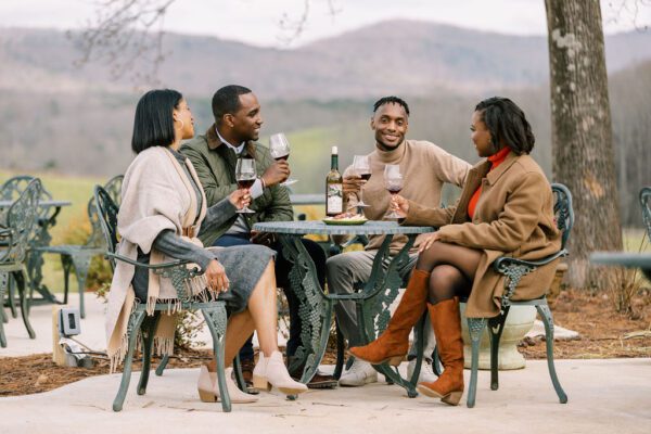 friends drinking wine outdoors during winter