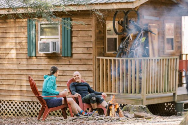 man and woman relaxing at a fire after a bike ride