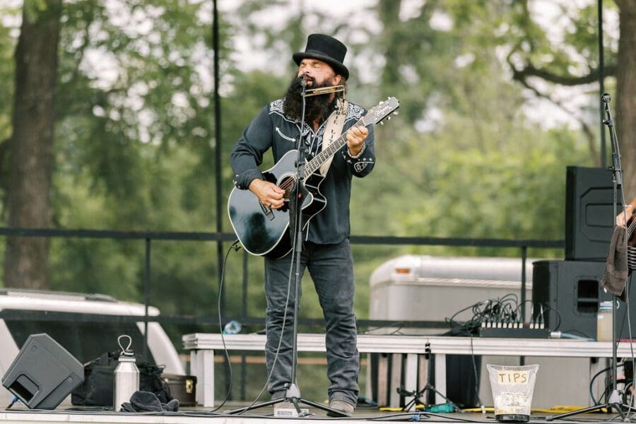 A man on stage singing and playing guitar