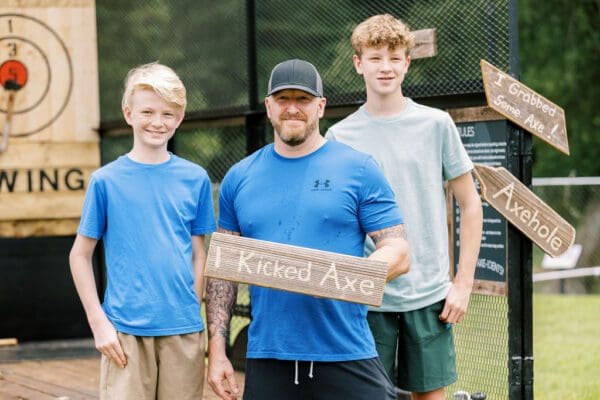 a father and sons axe throwing