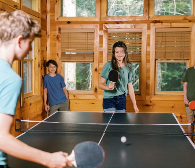 children playing ping pong in a cabin