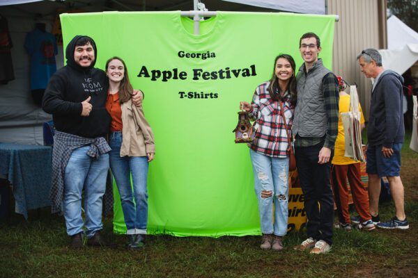 guests standing in front of Apple Festival t-shirts display