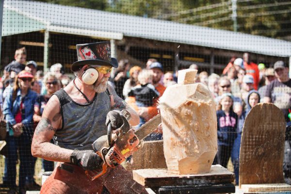 a man carving a log with a chainsaw