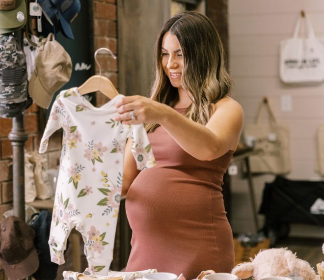 a pregnant woman browsing baby clothes