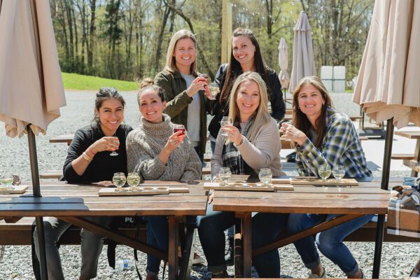a group of friends sampling wine outdoors