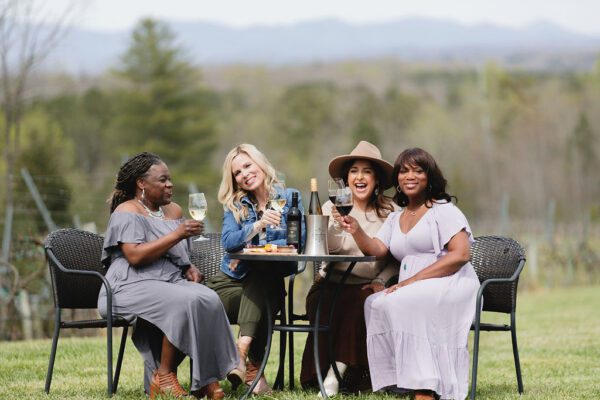 a group of women enjoying wine at a vineyard