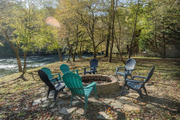 a fire pit surrounded by chairs in the fall