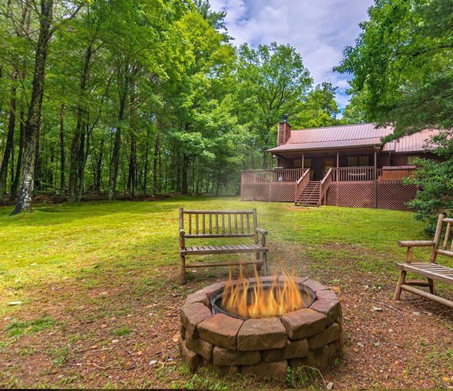 a firepit in front of a cabin for rent