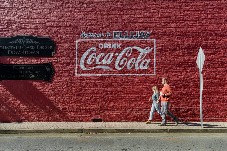 A brick wall with Welcome to Ellijay and the Coca Cola logo
